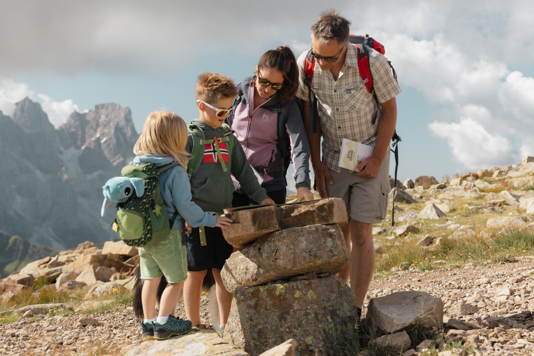 Una famiglia consulta la tavola di pietra sul sentiero