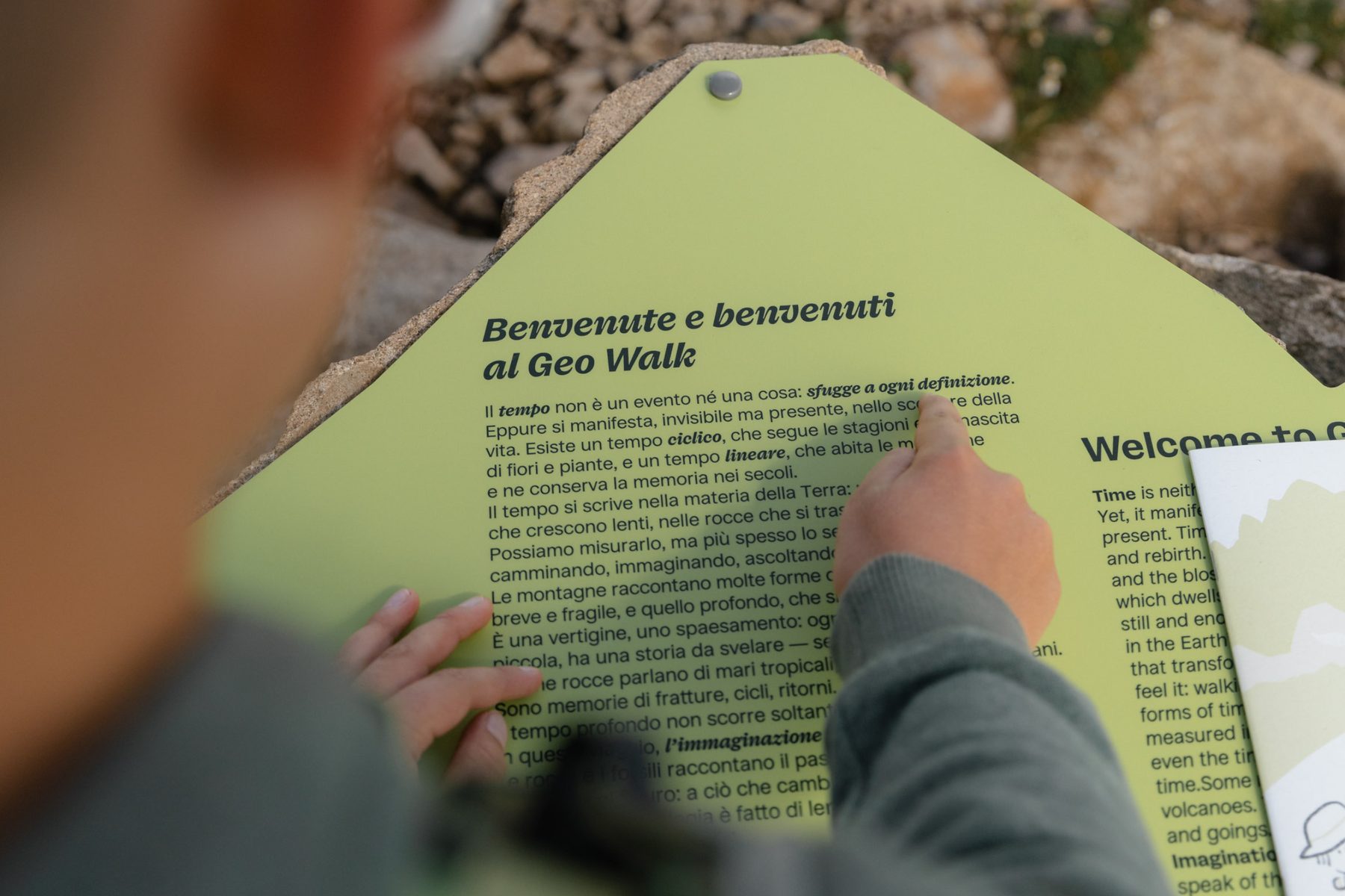 Un bambino segue il testo del pannello di benvenuto