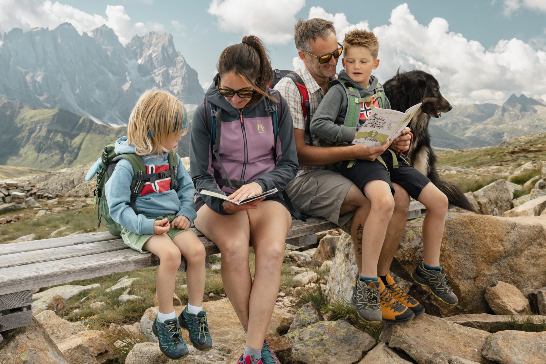 La famiglia legge la guida seduta su una panchina