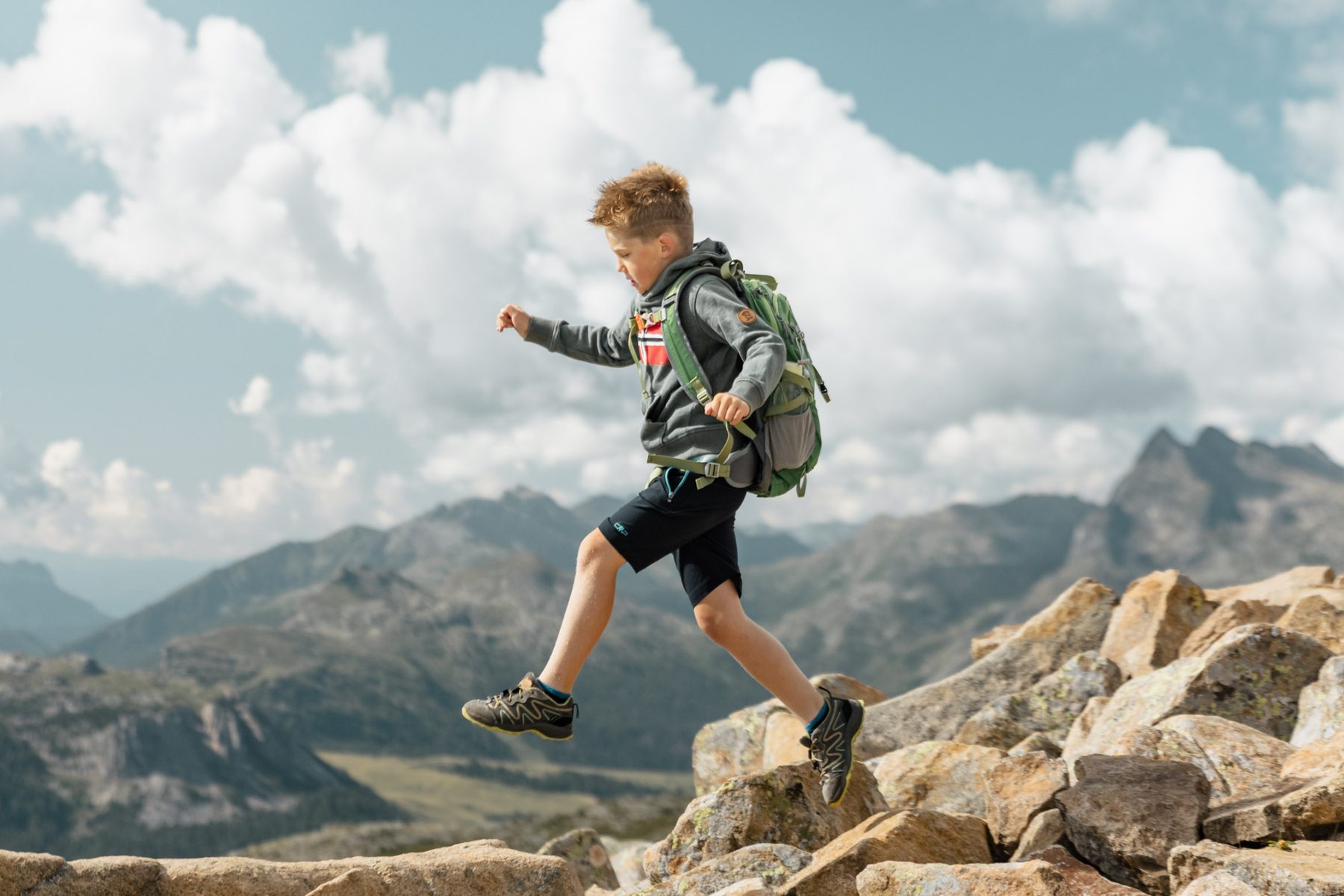 Un bambino salta tra le rocce